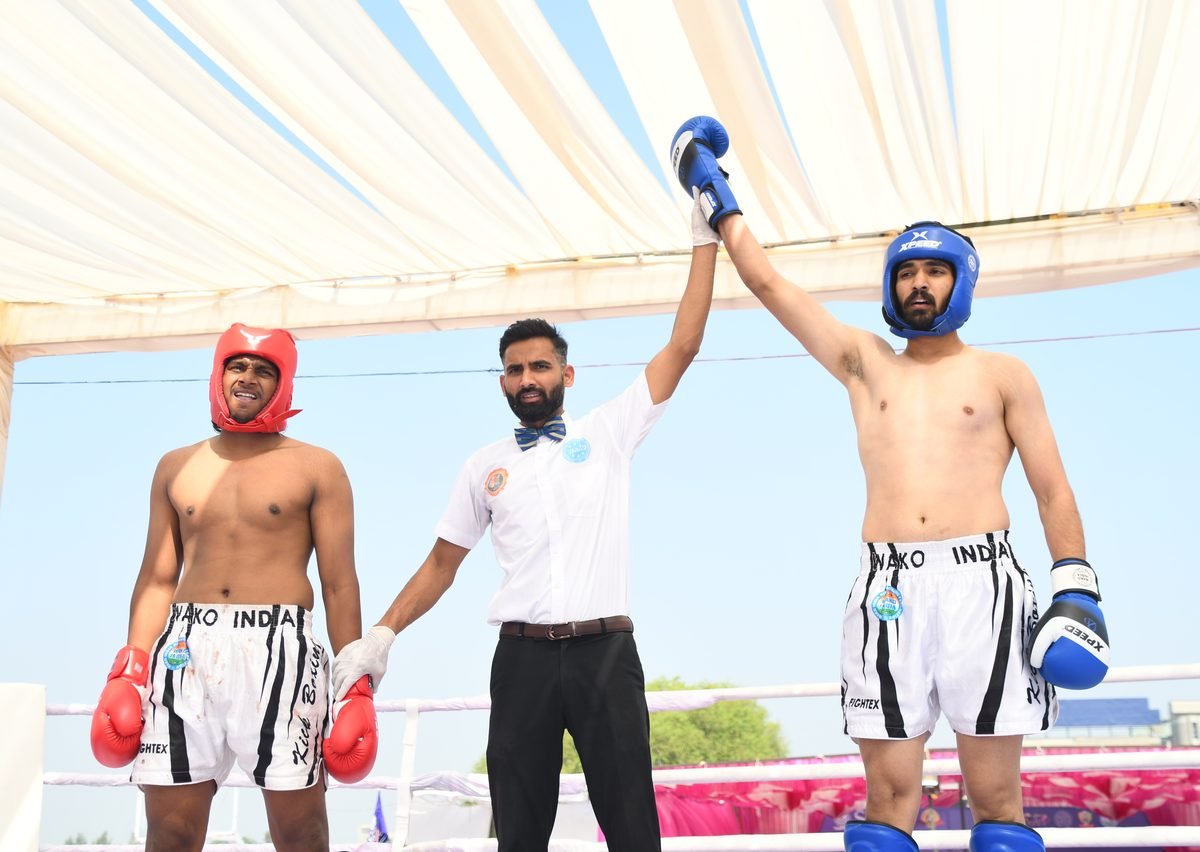 Referee raising the winner's hand at a WAKO India kickboxing bout